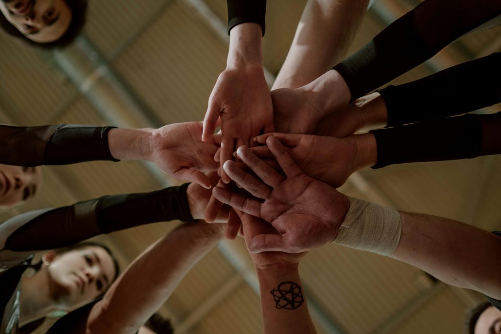 pexels photo 7322770 7322770 Group of people in a huddle showing unity and teamwork.